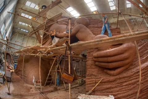 An image created by photographer David McBride of Zhang Yaxi's Mother and Child sculpture - showing the sculptor working on her monumental sculpture at the clay stage